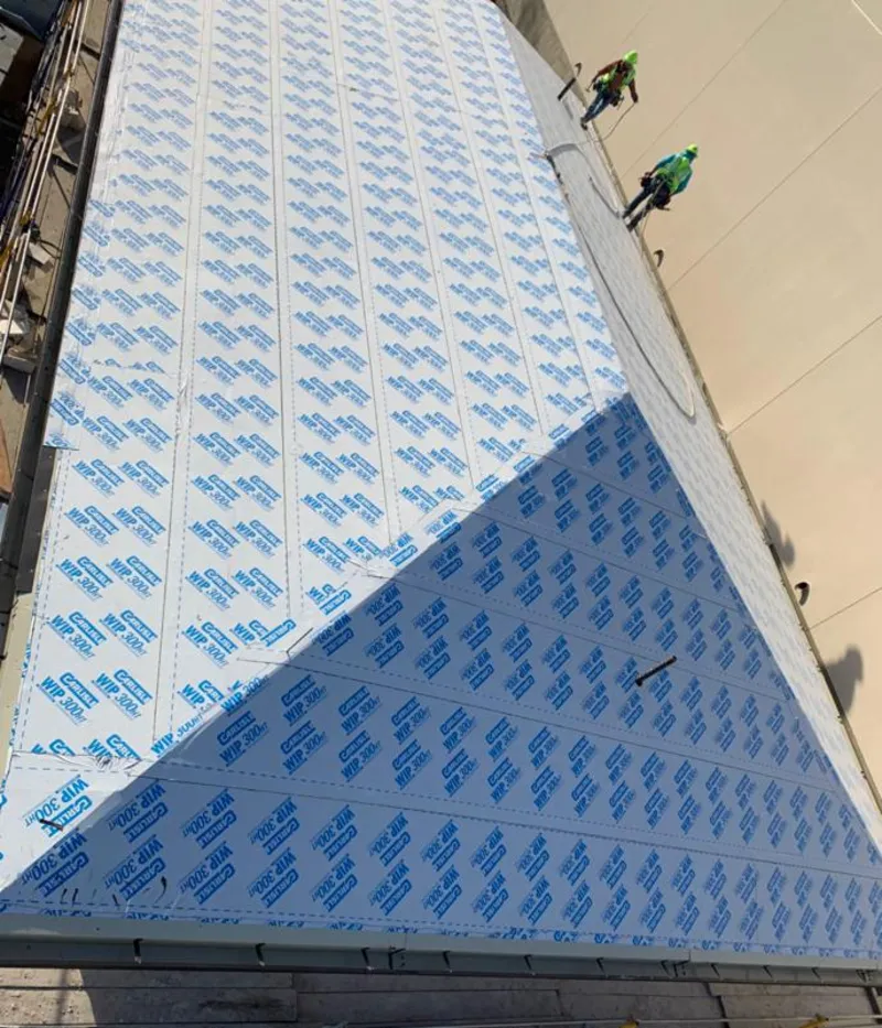 Professional roofers installing underlayment on a metal roof in Rexburg